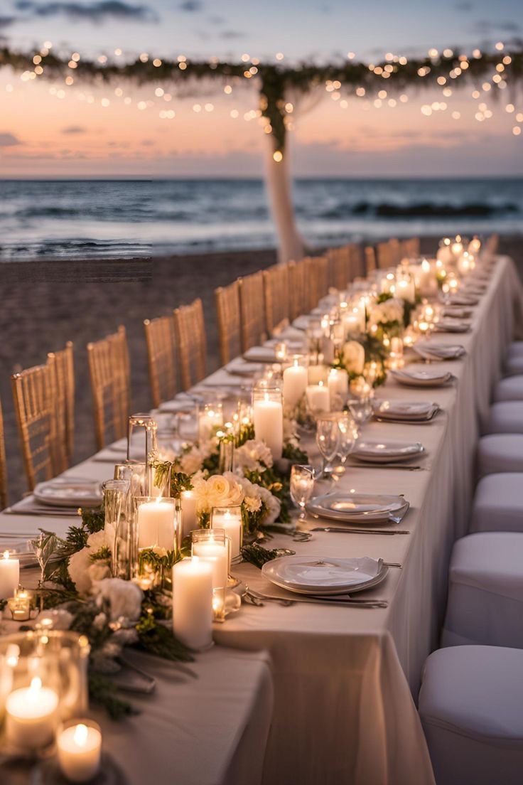 Mesa larga frente al mar con velas al atardecer