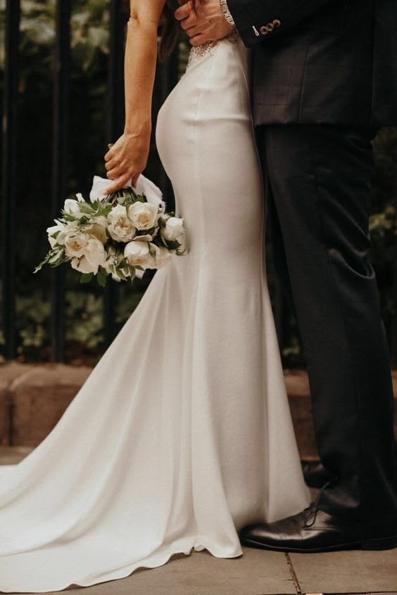 Pareja de novios con ramo de flores blancas